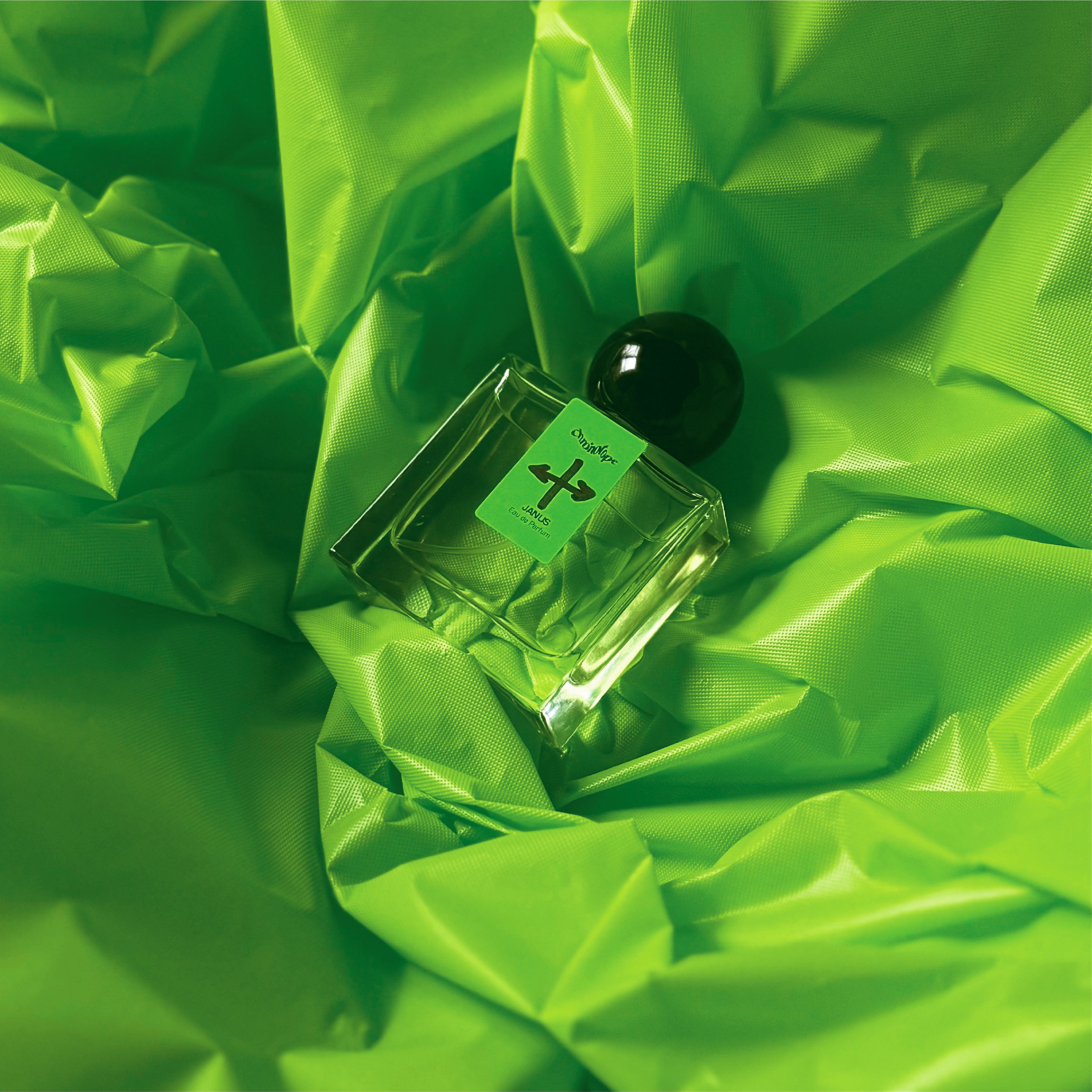Janus Eau de Parfum, the first installment of Chronotope Perfume’s newest collection of fragrances called the Neon Series, rests atop a crinkled background of neon green vinyl.