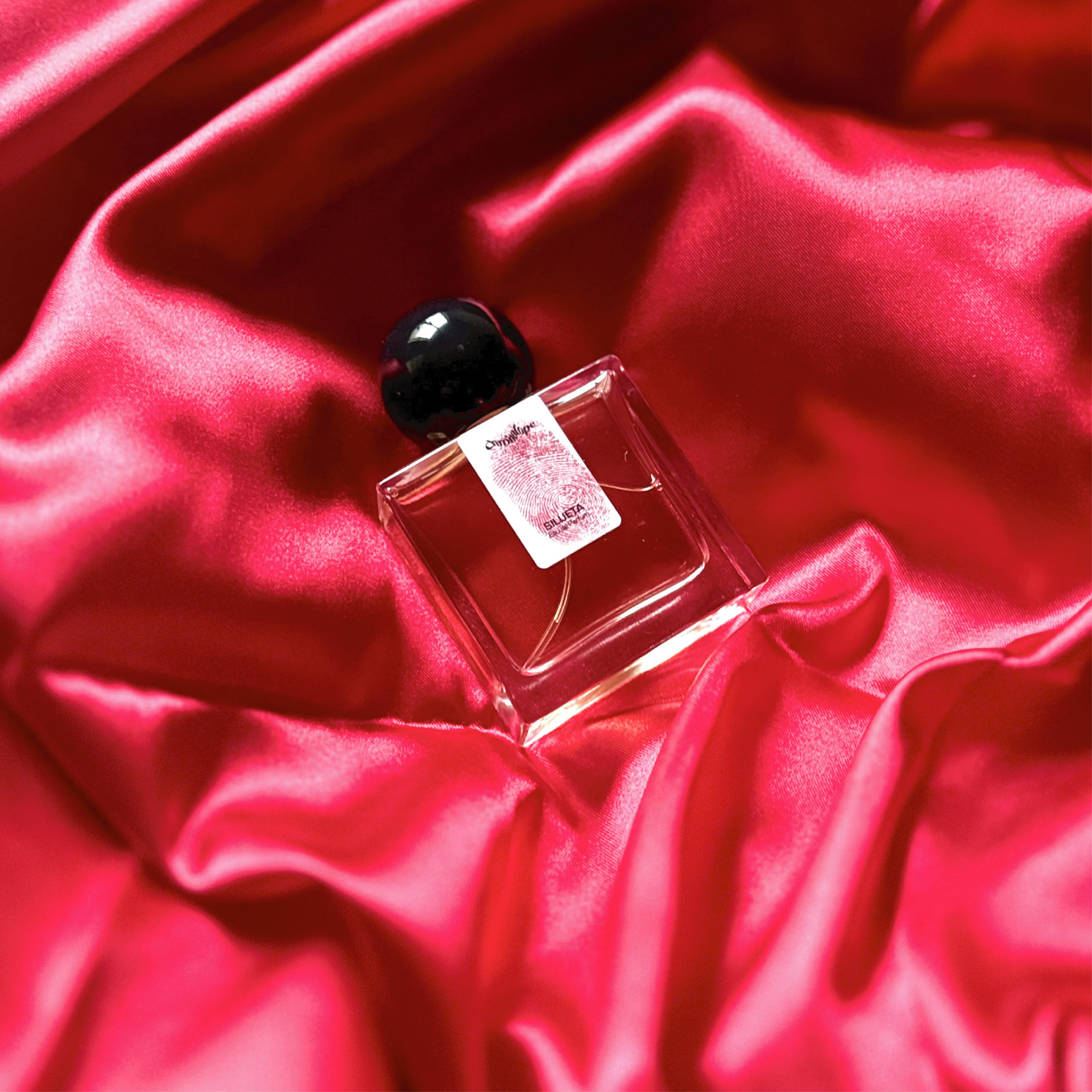 Chronotope perfume’s Silueta EdP lies in a shimmering nest of fabric in the same blood red color as the thumbprint on the perfume bottle’s label.