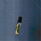 2mL spray sample of Chronotope Perfume’s Buen Camino Extrait de Parfum, featuring a golden enameled tip and matching Amberlit Gold label, shown against a dark gray background.
