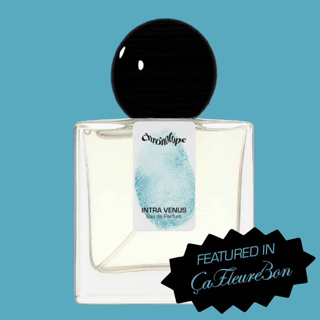 Digital rendering of Chronotope Perfume’s Intra Venus Eau de Parfum bottle with a white label stamped with the perfumer’s thumbprint in Hospital Blue, containing pale blue perfume, and set against a matching Hospital Blue background with a badge noting press coverage in ÇaFleureBon.