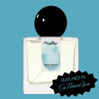 Digital rendering of Chronotope Perfume’s Intra Venus Eau de Parfum bottle with a white label stamped with the perfumer’s thumbprint in Hospital Blue, containing pale blue perfume, and set against a matching Hospital Blue background with a badge noting press coverage in ÇaFleureBon.