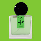 Digital rendering of Chronotope Perfume’s Janus Eau de Parfum 30 mL bottle from the brand’s Neon Series. The bottle features a vibrant fluorescent green — or Kaleidoscopic Green — label hand-marked by the perfumer with a black mirrored-cross symbol representing the dual nature of the fragrance and the deity for which it is named. It contains pale green perfume and is set against a matching Kaleidoscopic Green background.