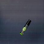 2mL spray sample of Chronotope Perfume’s Spite Eau de Parfum with green label and matching enameled tip, resting on a charcoal gray surface.